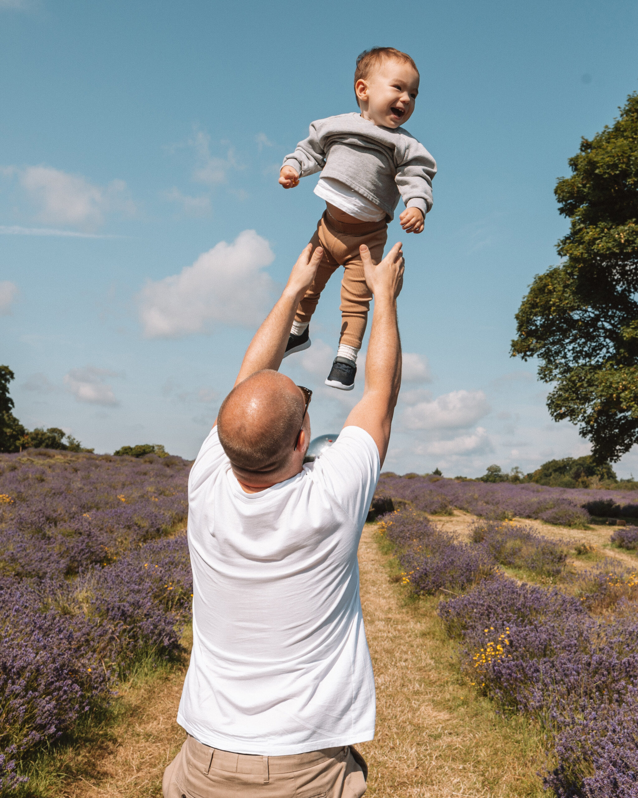 dad throwing toddler son up in the air